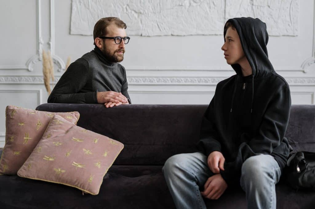Adolescent and adult interacting in a therapy setting.
