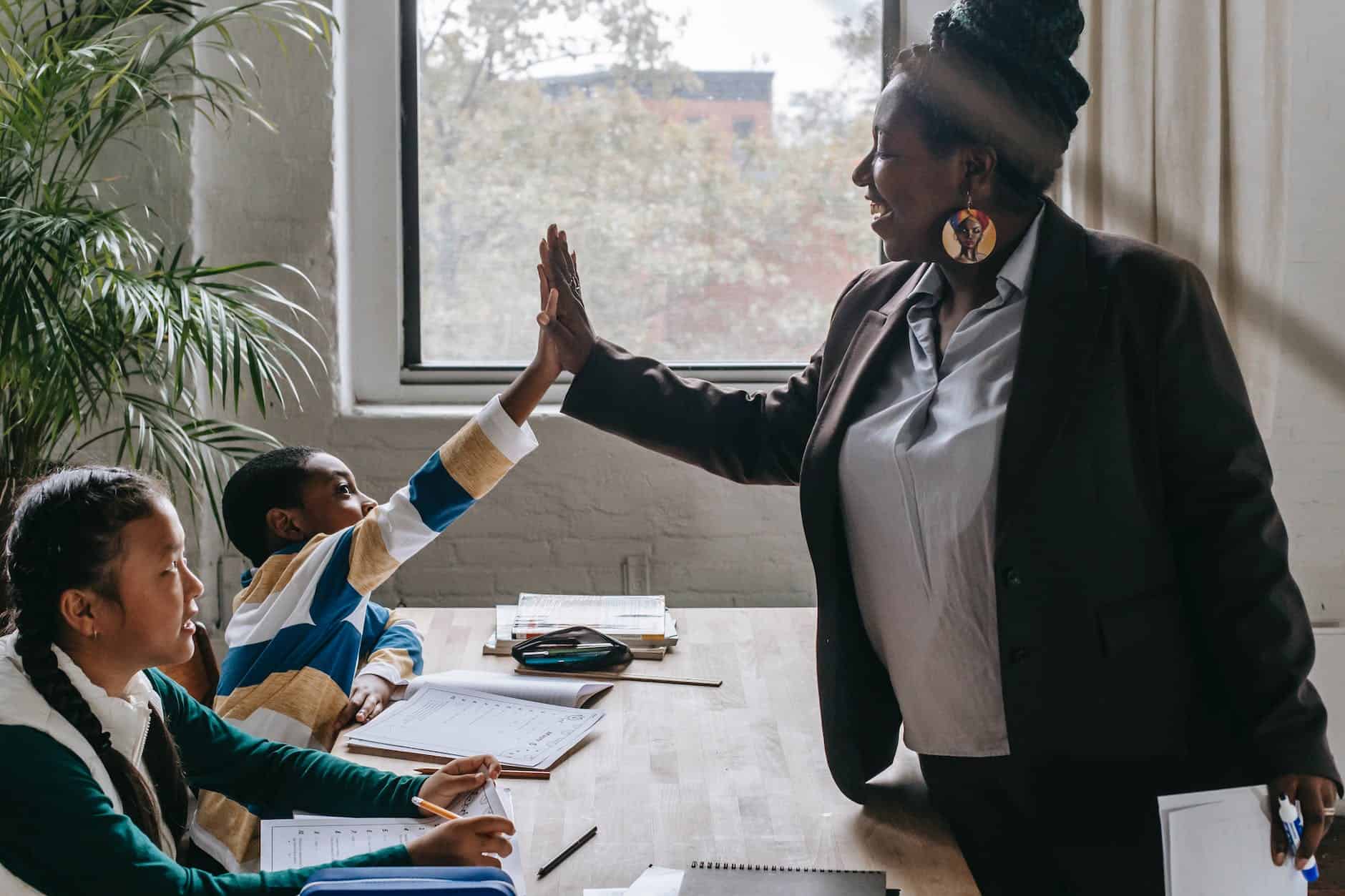 cheerful black teacher with diverse schoolkids