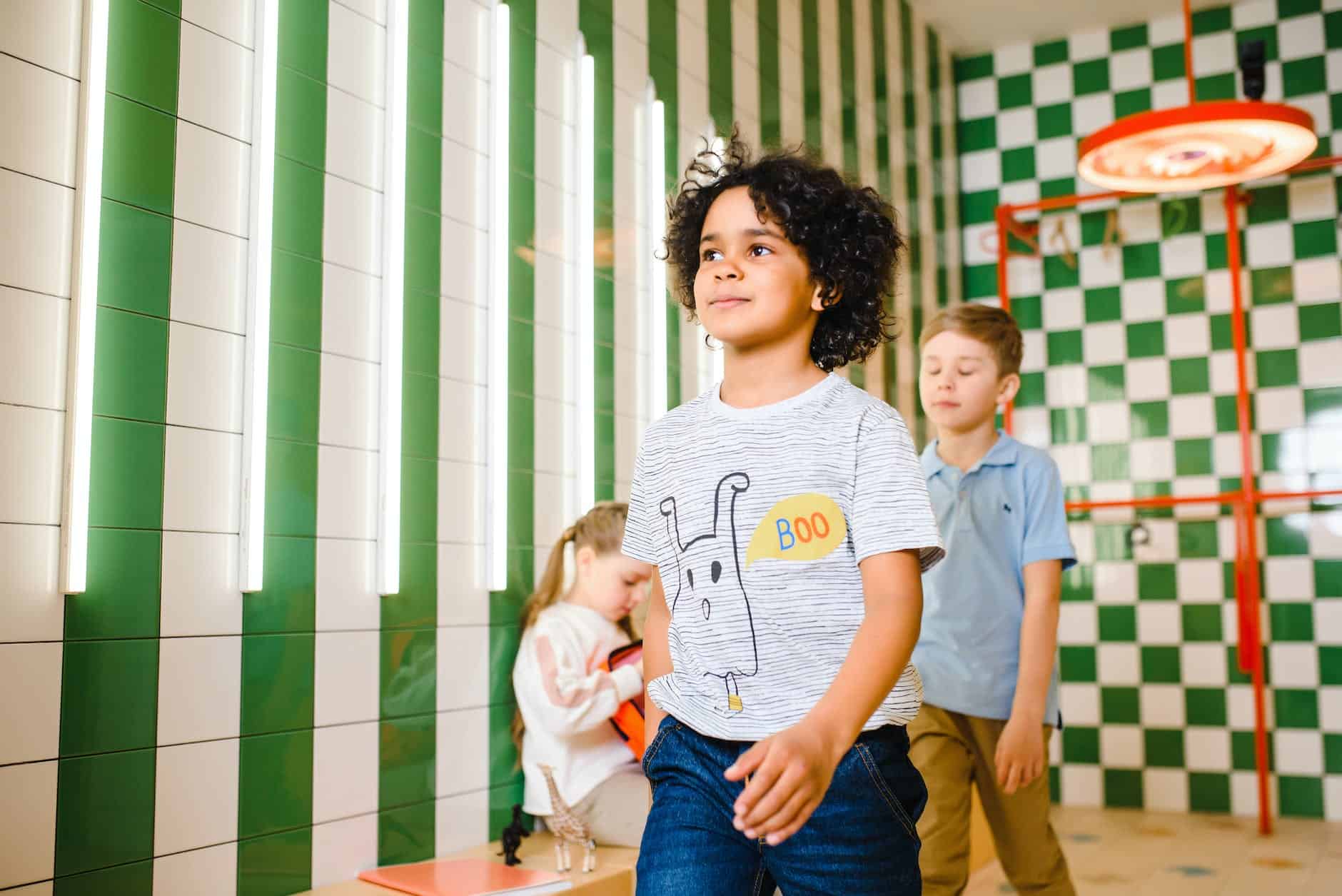 a boy with curly hair walking