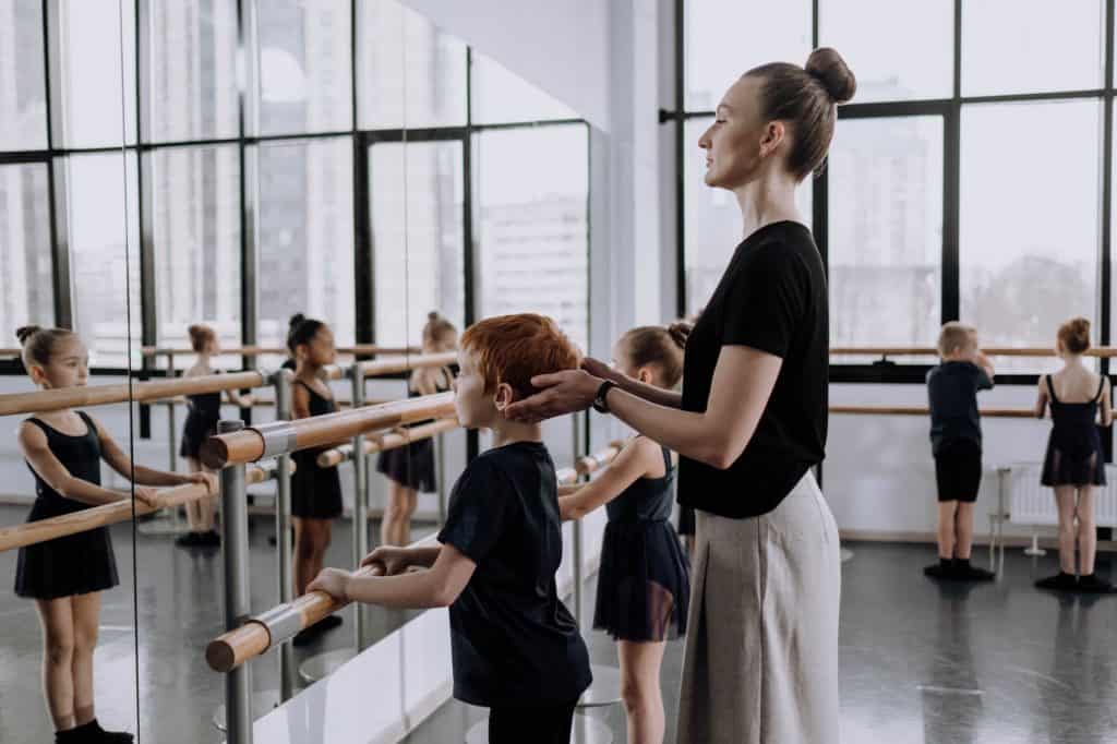 a woman teaching a boy in a dance class