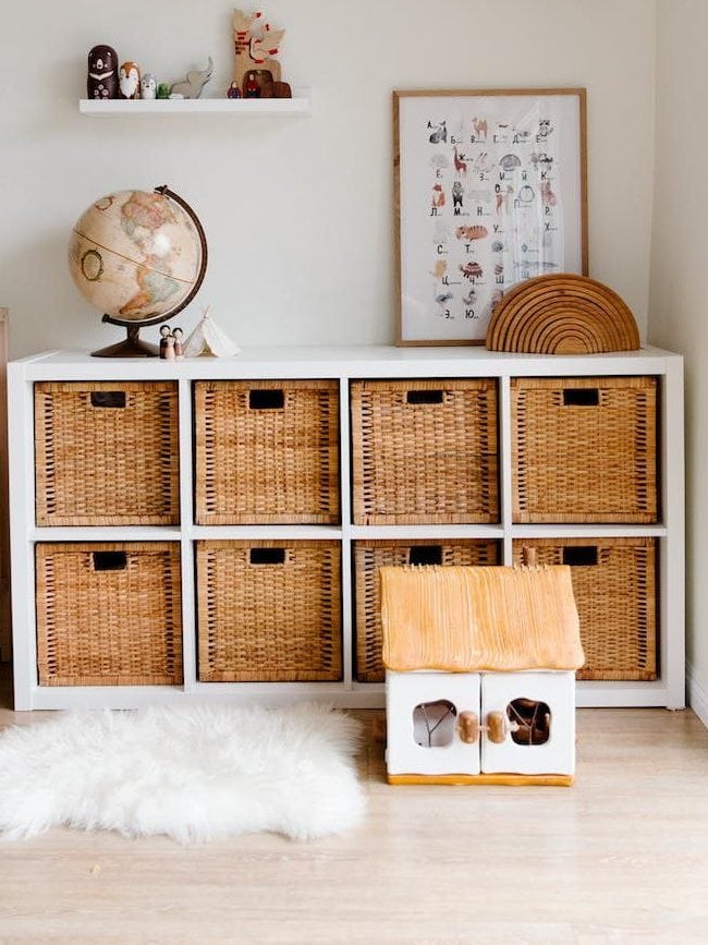 interior of children bedroom with wooden furniture and toys and globe placed on shelves in room