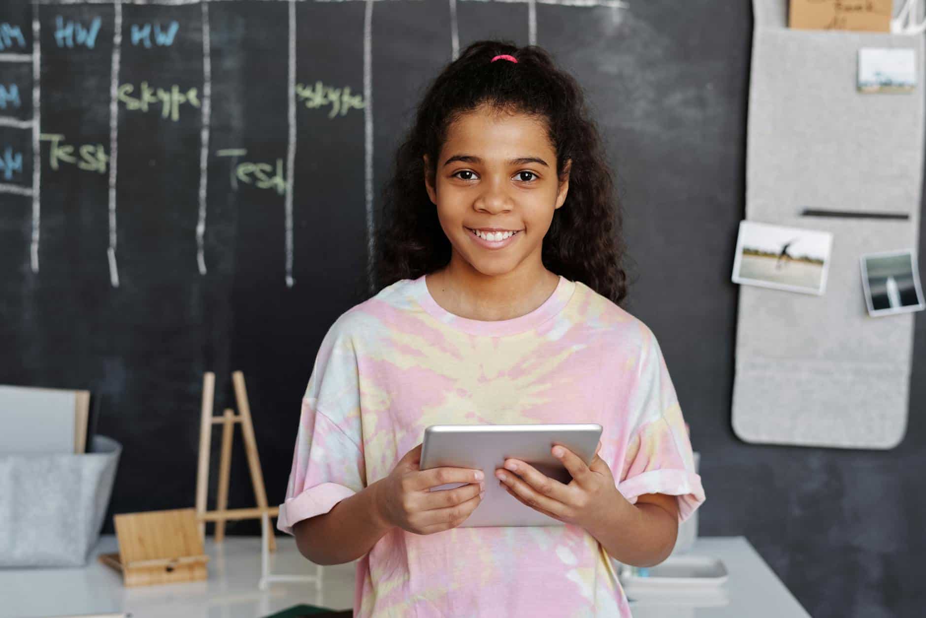 woman in pink crew neck t shirt holding tablet computer