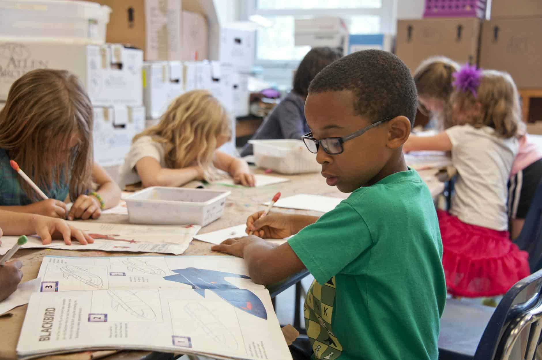 boy in class looking at book