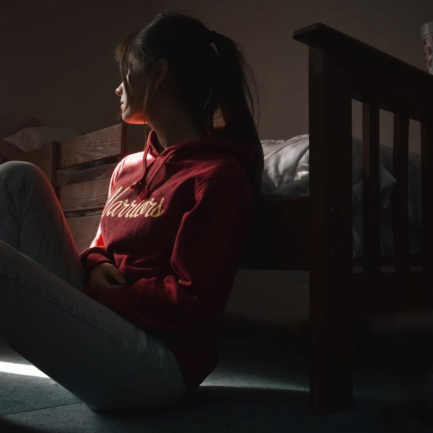 photo of woman sitting on floor